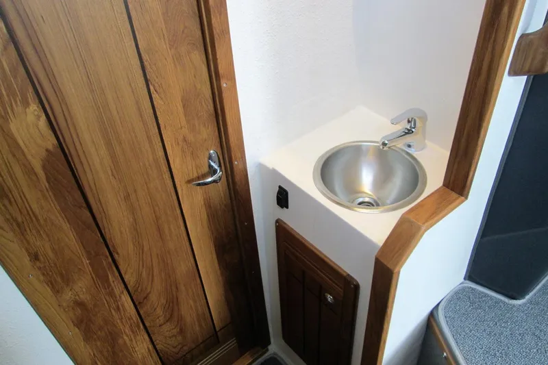 Slide: The Image of Compact sink area with wooden door in 2026 Sea Sport Pacific 3200 boat interior. - 20