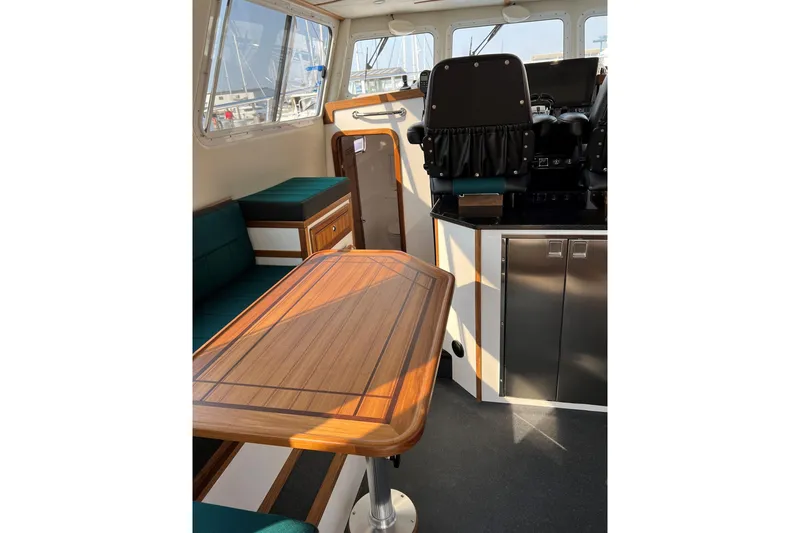 Slide: The Image of Interior of 2026 Sea Sport Pacific 3200 boat with wooden table and seating. - 23