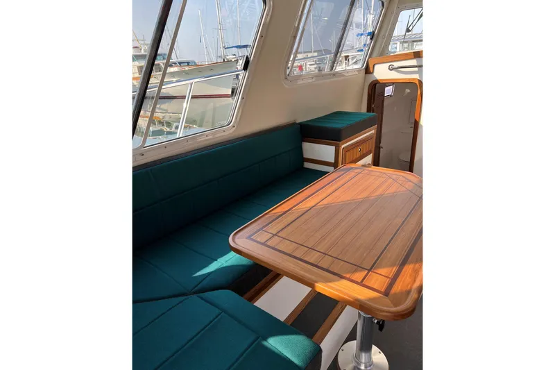 Slide: The Image of Interior of 2026 Sea Sport Pacific 3200 with teal seating and wooden table. - 24