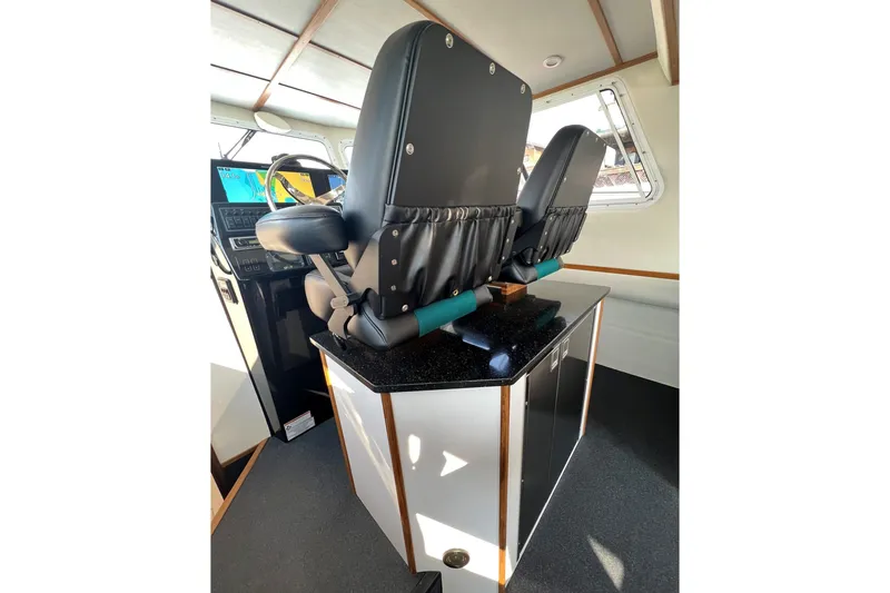 Slide: The Image of Interior of 2026 Sea Sport Pacific 3200 boat with dual captain's chairs and navigation equipment. - 3