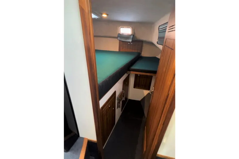 Slide: The Image of Interior cabin of 2026 Sea Sport Pacific 3200 boat with wooden accents and green bedding. - 6
