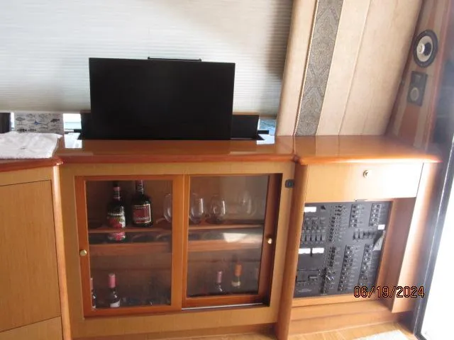 Slide: The Image of Interior of 2004 Ocean Yachts Super Sport with bar cabinet and electronics panel. - 11