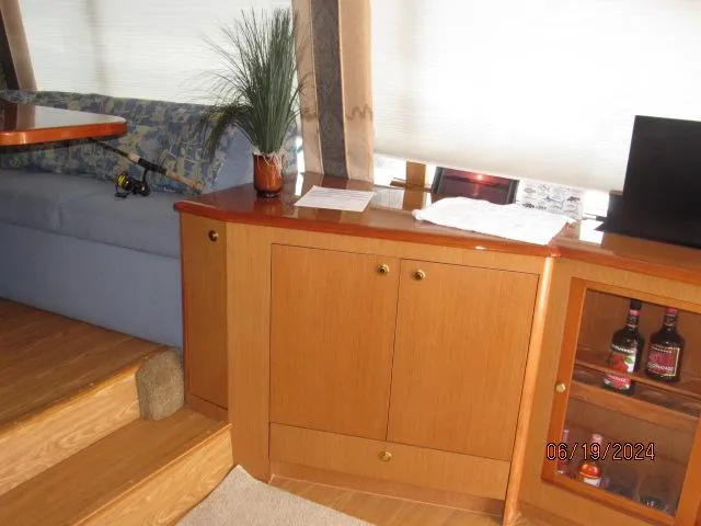 Slide: The Image of Interior of 2004 Ocean Yachts Super Sport with wooden cabinets and blue seating. - 14