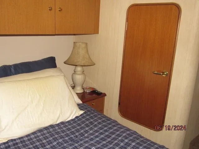 Slide: The Image of Cozy bedroom in 2004 Ocean Yachts Super Sport with bed, lamp, and wooden door. - 19