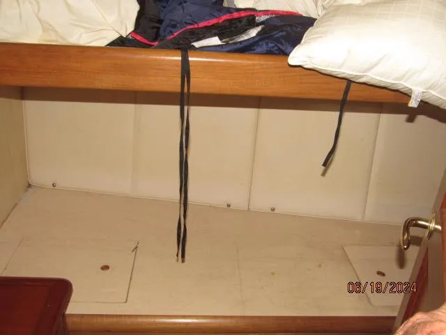 Slide: The Image of 2004 Ocean Yachts Super Sport cabin interior with storage space and bedding. - 20