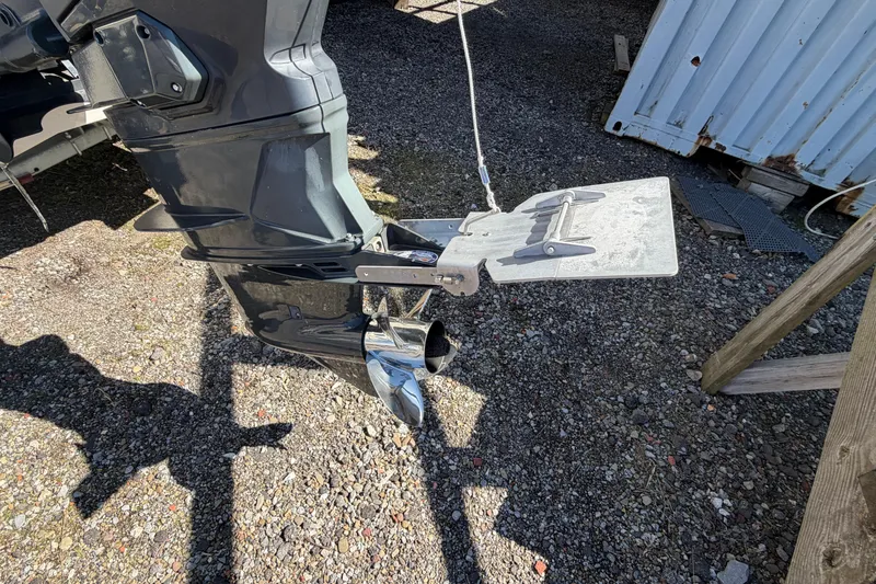 Slide: The Image of Outboard motor and trim tab of 2017 Sea Chaser 24 HFC on gravel surface. - 12