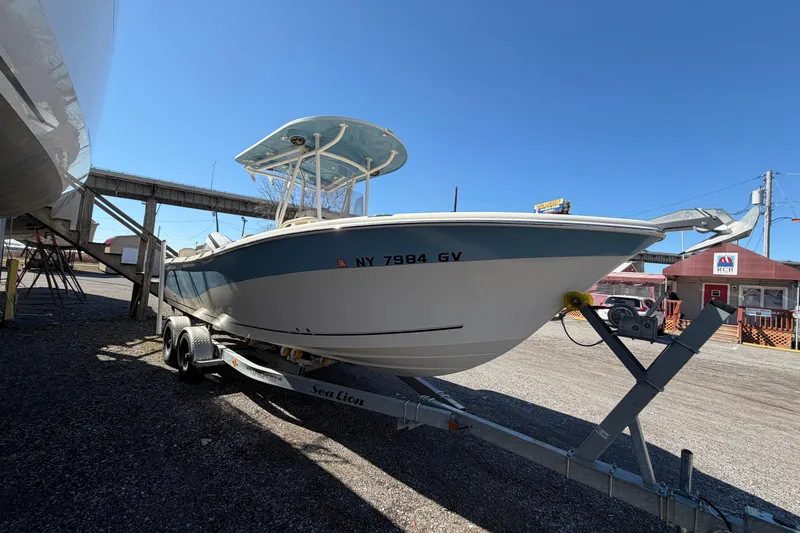 Slide: The Image of 2017 Sea Chaser 24 HFC boat on trailer, parked outdoors under clear blue sky. - 18