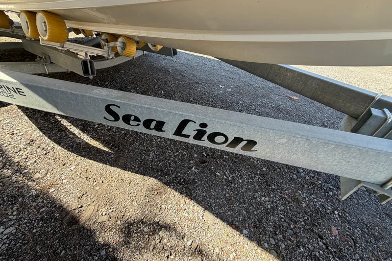 Slide: The Image of Trailer for 2017 Sea Chaser 24 HFC boat, labeled "Sea Lion," on gravel surface. - 23