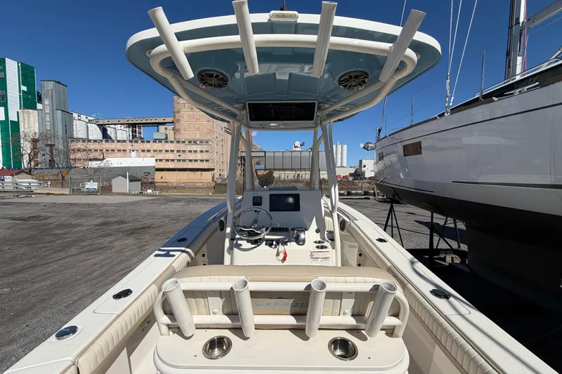 Slide: The Image of 2017 Sea Chaser 24 HFC boat with T-top and rod holders, docked in an industrial area. - 24