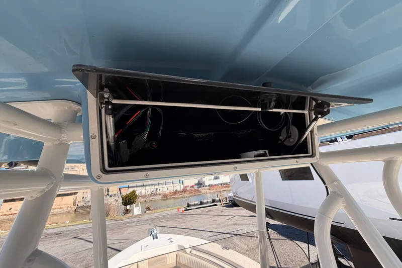 Slide: The Image of Open storage compartment on a 2017 Sea Chaser 24 HFC boat, showing wiring and equipment. - 28