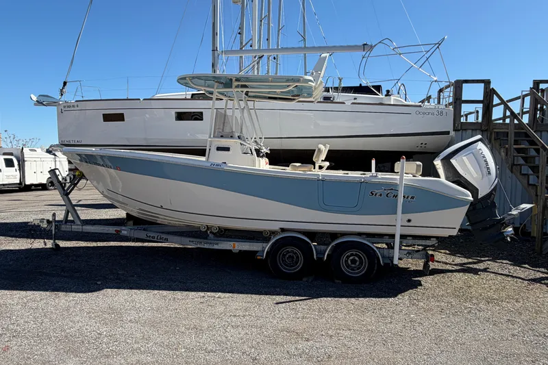 Slide: The Image of 2017 Sea Chaser 24 HFC boat on trailer, parked near a larger sailboat. - 3