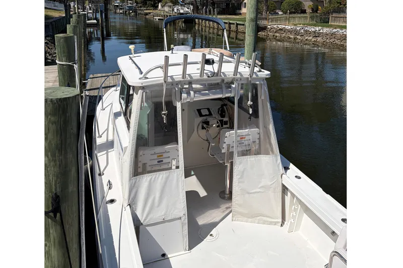 Slide: The Image of 2005 Steiger Craft 23 Miami boat docked in a serene canal setting. - 11