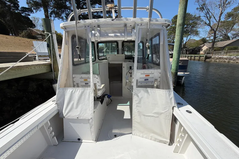 Slide: The Image of 2005 Steiger Craft 23 Miami boat docked, featuring a spacious cockpit and enclosed helm. - 17