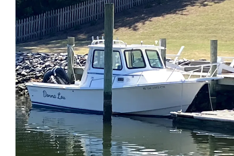 Slide: The Image of 2005 Steiger Craft 23 Miami boat docked by a wooden pier. - 2