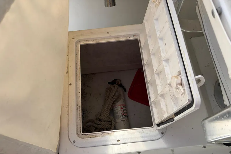 Slide: The Image of 2005 Steiger Craft 23 Miami boat storage compartment with rope and fire extinguisher. - 20