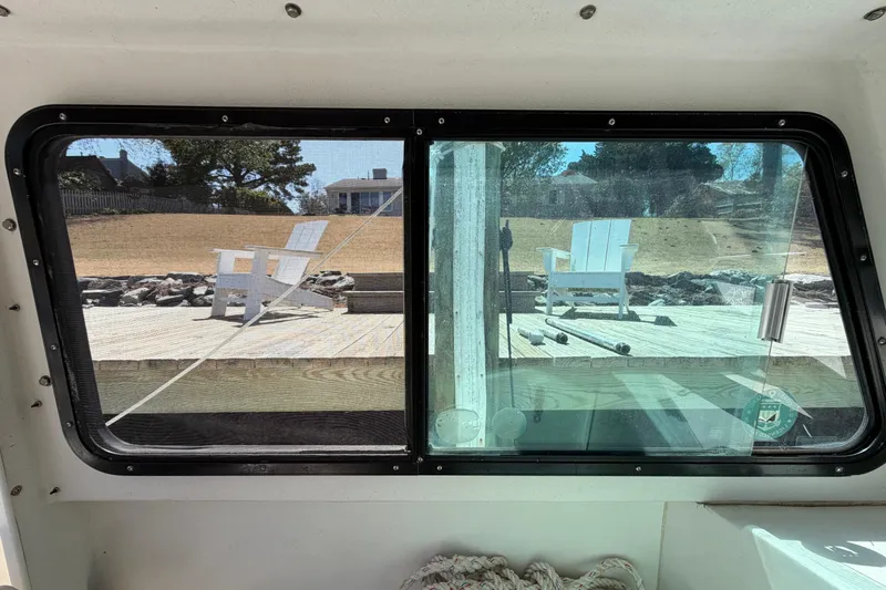 Slide: The Image of View from inside a 2005 Steiger Craft 23 Miami boat, looking out at a deck with chairs. - 24