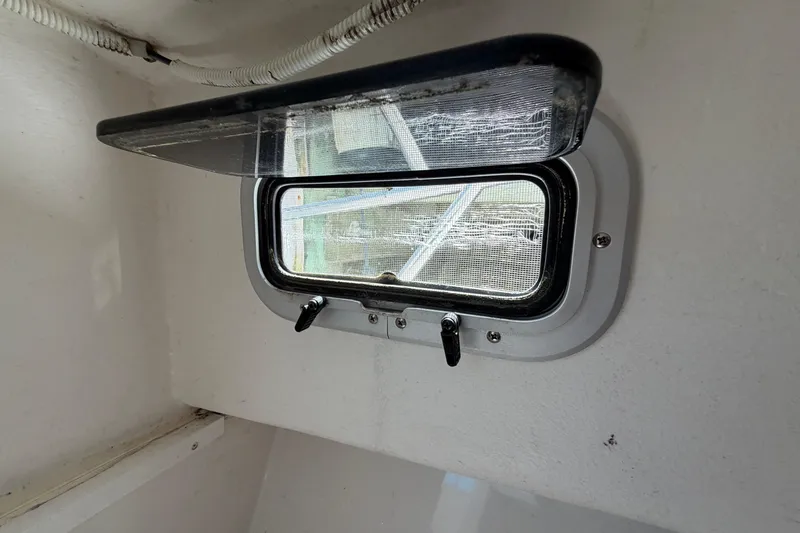 Slide: The Image of Boat cabin window in a 2005 Steiger Craft 23 Miami, featuring a screen and latches. - 34