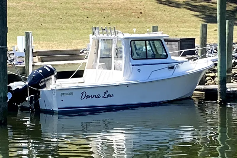 Slide: The Image of 2005 Steiger Craft 23 Miami boat docked, named "Donna Lou," with outboard motor. - 37