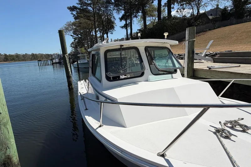 Slide: The Image of 2005 Steiger Craft 23 Miami boat docked by a serene waterfront. - 6