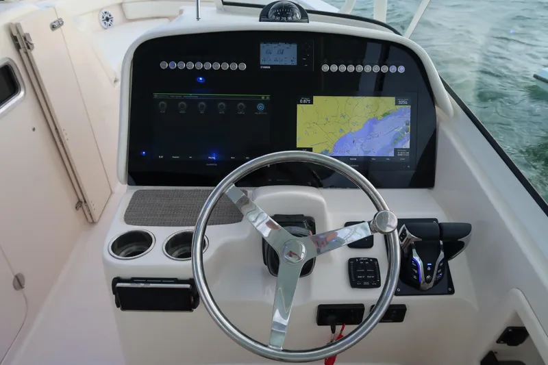 Slide: The Image of 2018 Grady-White Freedom 307 boat dashboard with navigation display and steering wheel. - 21