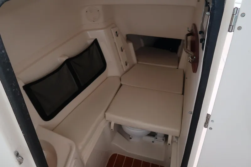 Slide: The Image of 2018 Grady-White Freedom 307 cabin interior with seating and compact toilet. - 25