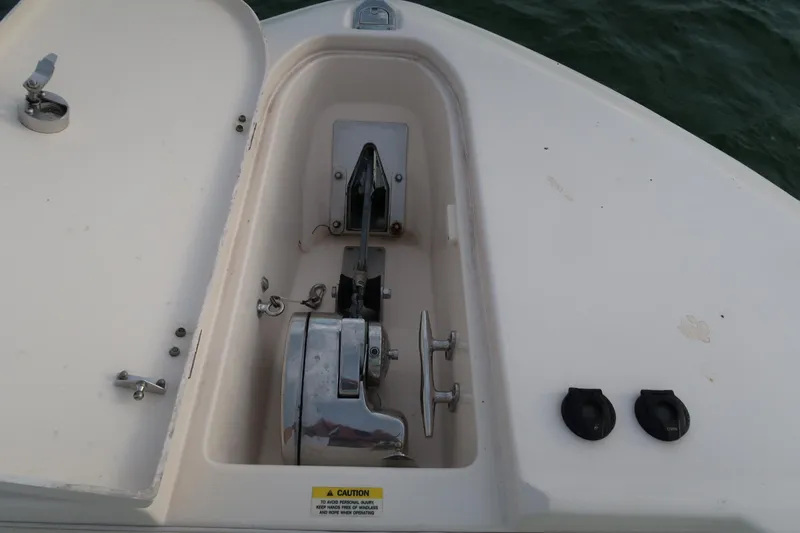 Slide: The Image of Anchor compartment of 2018 Grady-White Freedom 307 boat, featuring winch and cleat. - 29