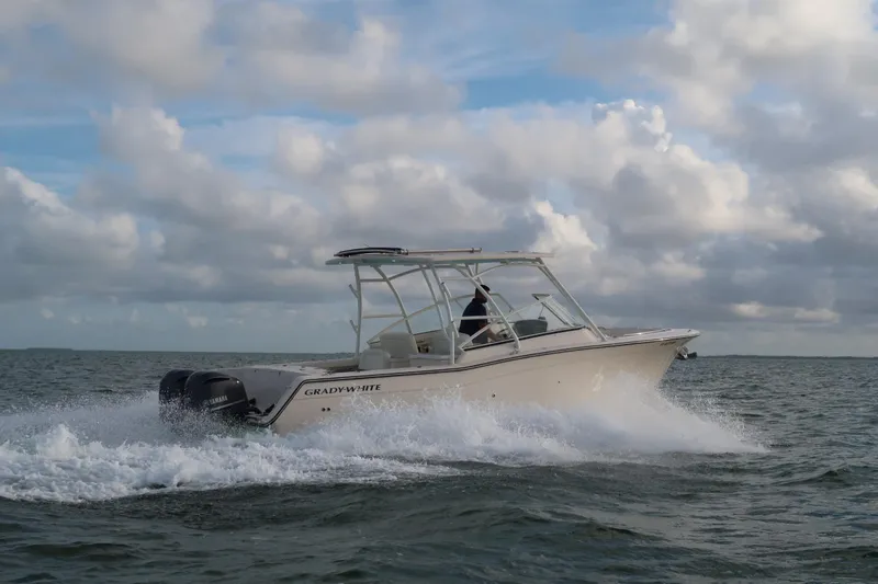 Slide: The Image of 2018 Grady-White Freedom 307 boat cruising on open water under cloudy skies. - 35