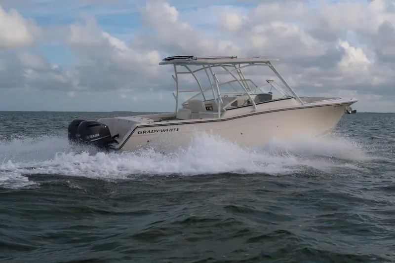 Slide: The Image of 2018 Grady-White Freedom 307 boat cruising on open water under cloudy skies. - 36