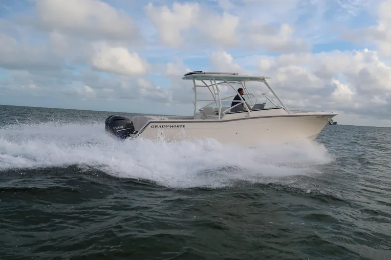 Slide: The Image of 2018 Grady-White Freedom 307 boat cruising on open water under cloudy sky. - 37