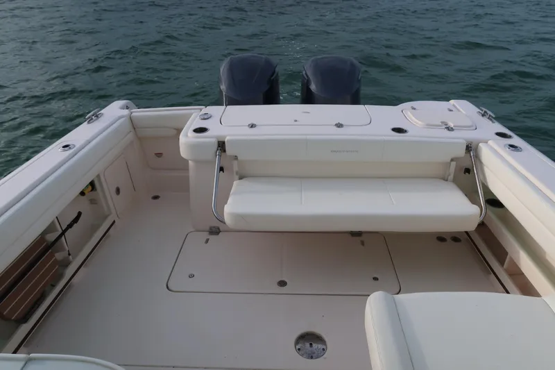 Slide: The Image of 2018 Grady-White Freedom 307 boat interior with seating and dual engines on water. - 7