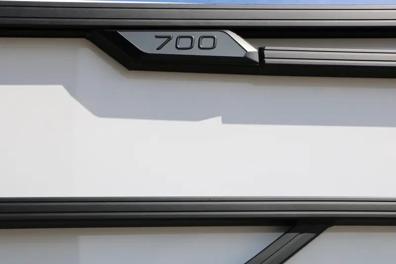 Slide: The Image of Close-up of Evotti 725 CS Tri-Toon 2026, featuring sleek black trim and "700" emblem. - 11