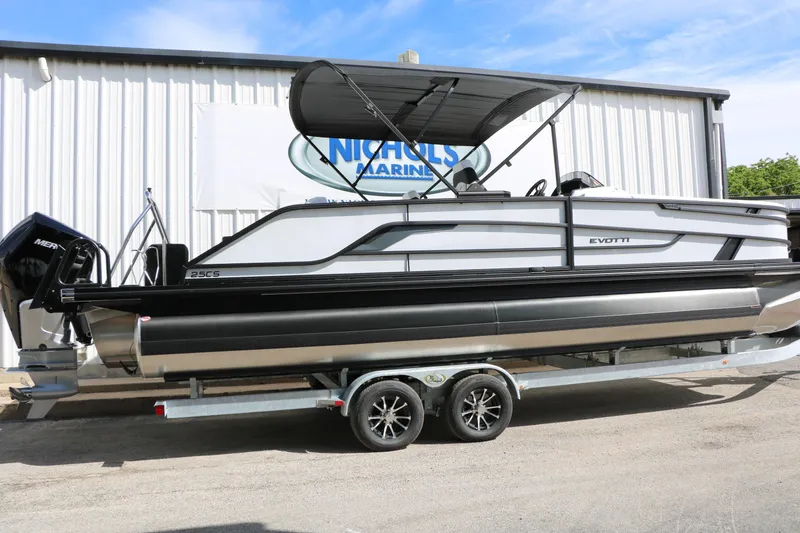 Slide: The Image of 2026 Evotti 725 CS Tri-Toon boat on trailer, parked outside Nichols Marine. - 2
