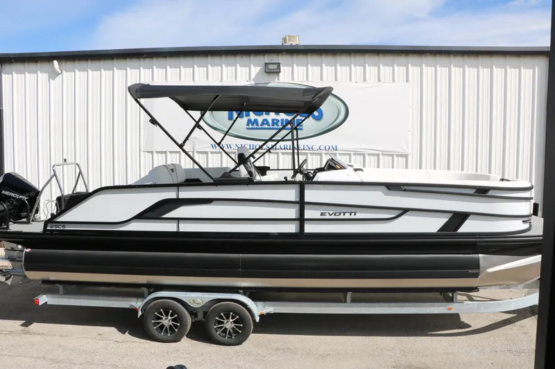 Slide: The Image of 2026 Evotti 725 CS Tri-Toon boat on trailer, side view, at marina. - 25