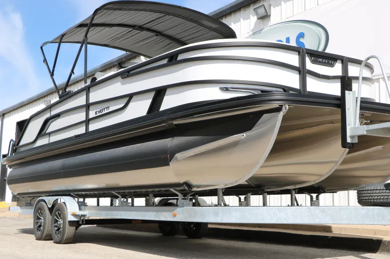 Slide: The Image of 2026 Evotti 725 CS Tri-Toon boat on trailer, featuring sleek design and modern canopy. - 26