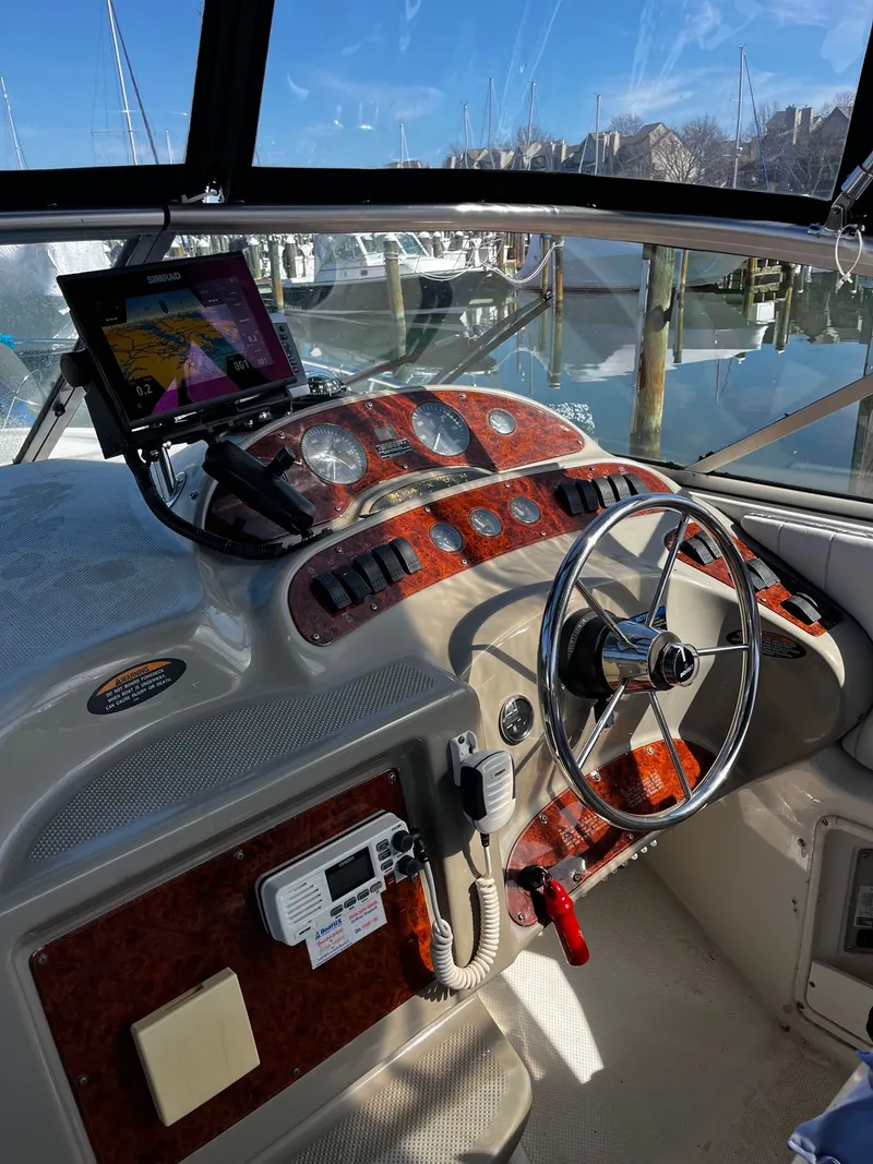 Slide: The Image of 1998 Maxum 2700 SCR yacht helm in marina setting. - 5