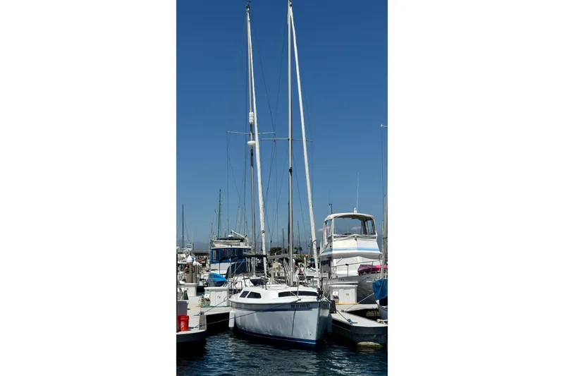 Slide: The Image of Sailboat Catalina 250, 2003 model, docked in a marina under clear blue skies. - 10
