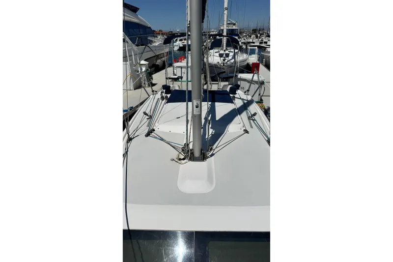 Slide: The Image of 2003 Catalina 250 sailboat docked in a marina, showcasing deck and mast details. - 11