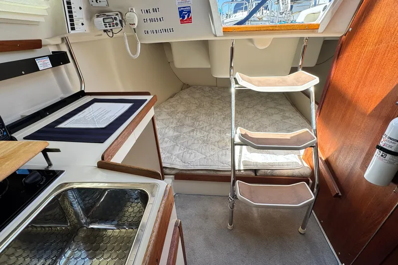 Slide: The Image of Interior of a 2003 Catalina 250 sailboat with compact kitchen and sleeping area. - 2