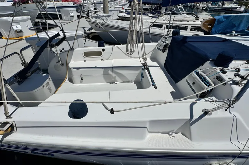 Slide: The Image of Catalina 250 sailboat from 2003 docked at a marina, showcasing its cockpit area. - 4