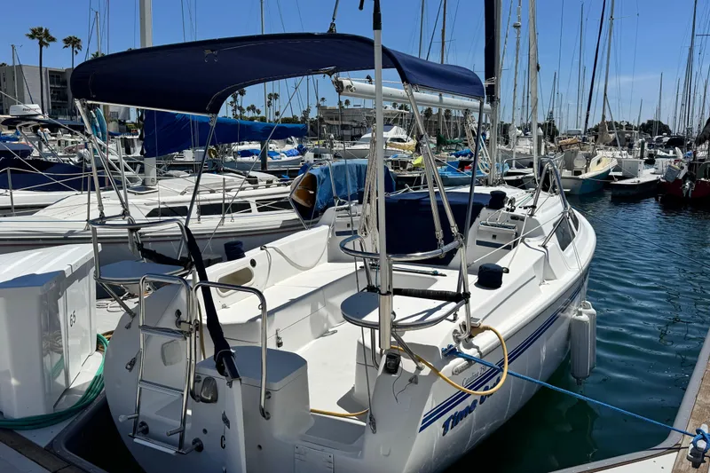 Slide: The Image of 2003 Catalina 250 sailboat docked in a marina, featuring a blue canopy and sleek design. - 5