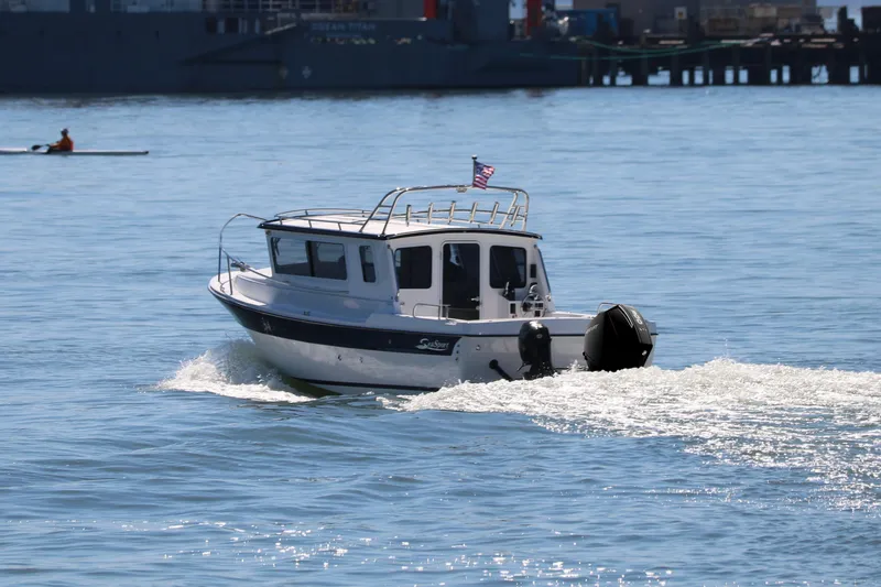 The Image of 2026 SeaSport Explorer 2400 cruising on calm waters with American flag. - 1