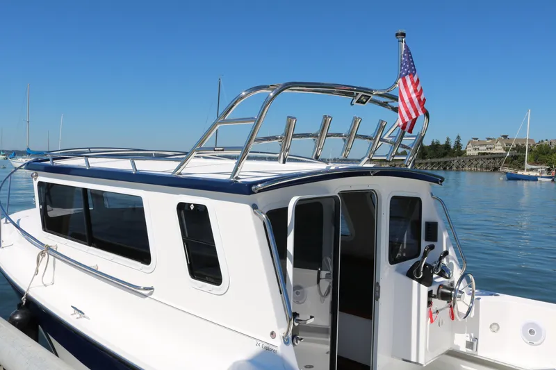 Slide: The Image of 2026 SeaSport Explorer 2400 boat docked, featuring sleek design and American flag. - 10