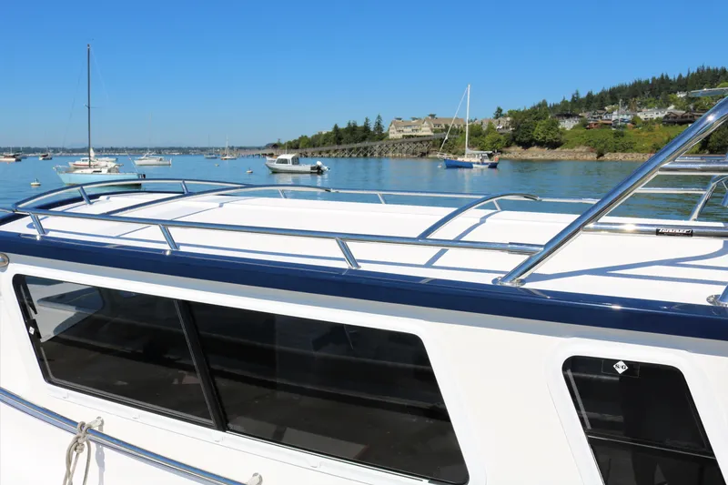 Slide: The Image of 2026 SeaSport Explorer 2400 boat docked in a scenic marina with clear blue skies. - 11