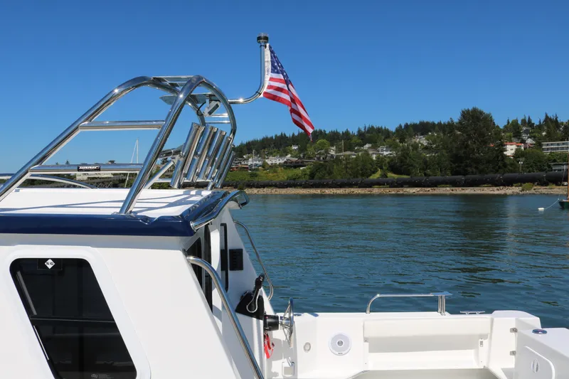 Slide: The Image of 2026 SeaSport Explorer 2400 boat with American flag on calm water. - 12