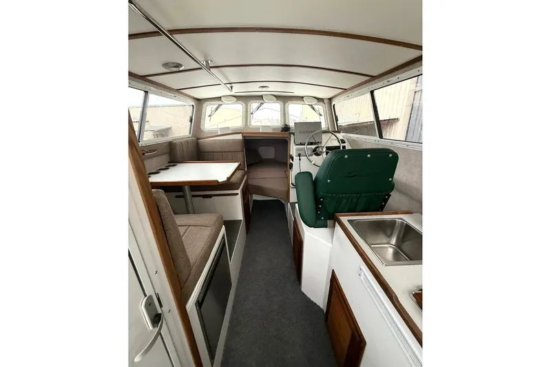Slide: The Image of Interior of 2026 SeaSport Explorer 2400 boat with seating, helm, and kitchenette. - 13