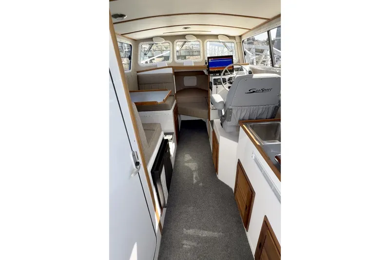 Slide: The Image of Interior of 2026 SeaSport Explorer 2400 boat, featuring helm, seating, and kitchenette. - 4