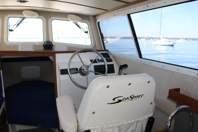 Slide: The Image of Interior of 2026 SeaSport Explorer 2400 boat with steering wheel and window view. - 7