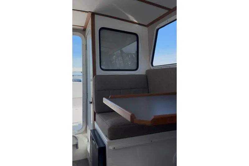 Slide: The Image of Interior of 2026 SeaSport Explorer 2400, featuring a cozy seating area with a table. - 8