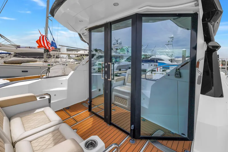 Slide: The Image of 2019 Beneteau Gran Turismo 46 yacht with elegant seating and glass doors at a marina. - 11