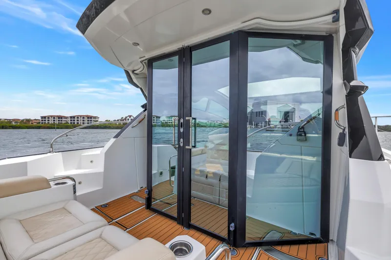 Slide: The Image of 2019 Beneteau Gran Turismo 46 yacht with sleek glass doors and luxurious seating on deck. - 12